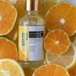 Brightening vitamin C serum surrounded by fresh sliced citrus fruits in a studio setting.